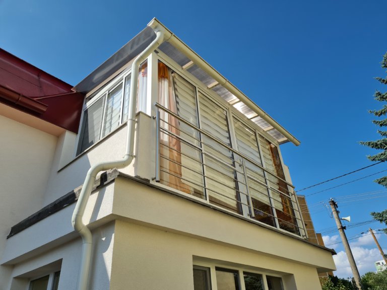 Moderně zařízený zasklený balkon s místem pro relaxaci